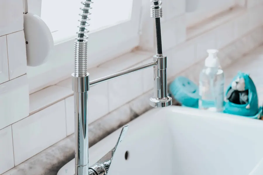 Chrome kitchen faucet over a white sink